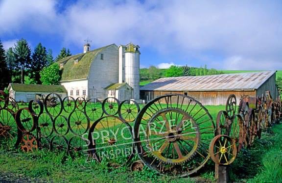 Ogrodzenie z przeróżnych metalowych kół, obręczy i zębatek